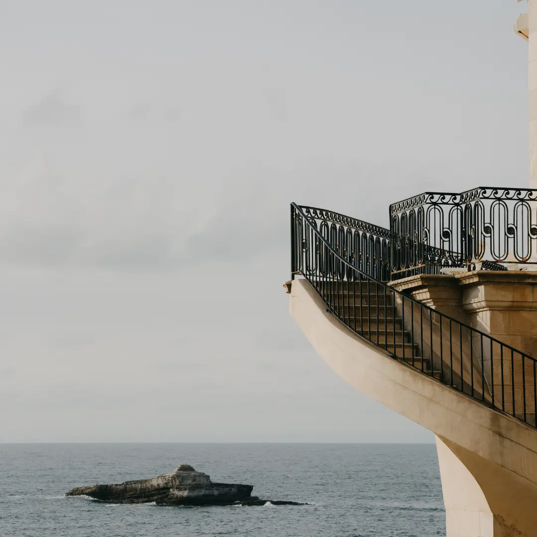 Dekoration: Eine steinerne Terrasse mit Blick auf das Meer und einen Felsen.
